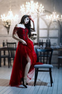 Kırmızı elbiseli kana susamış dişi vampir. Ortaçağ iç mimarisi