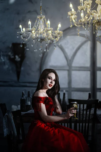 Krwawa wampirzyca w czerwonej sukience. Średniowieczne wnętrze — Zdjęcie stockowe
