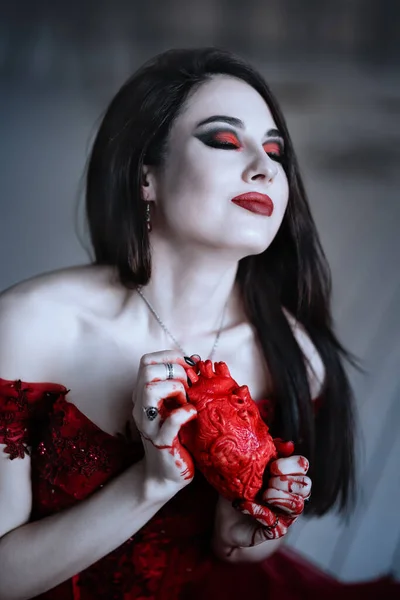 Blodtörstig kvinnlig vampyr i röd klänning. Medeltida interiör — Stockfoto