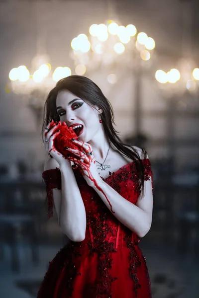 Blodtörstig kvinnlig vampyr i röd klänning. Medeltida interiör — Stockfoto
