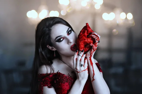 Bloeddorstige vrouwelijke vampier in rode jurk. Middeleeuws interieur — Stockfoto