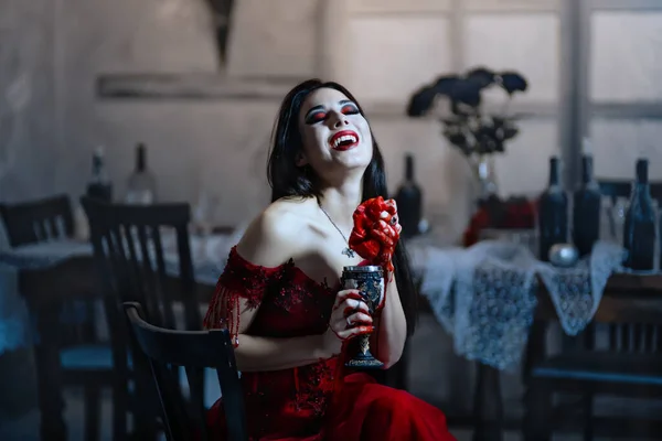 Αιμοδιψής βρικόλακας με κόκκινο φόρεμα. Μεσαιωνικό εσωτερικό — Φωτογραφία Αρχείου