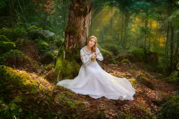 Beautiful young woman in a white dress in the middle of a forest — Stock Photo, Image