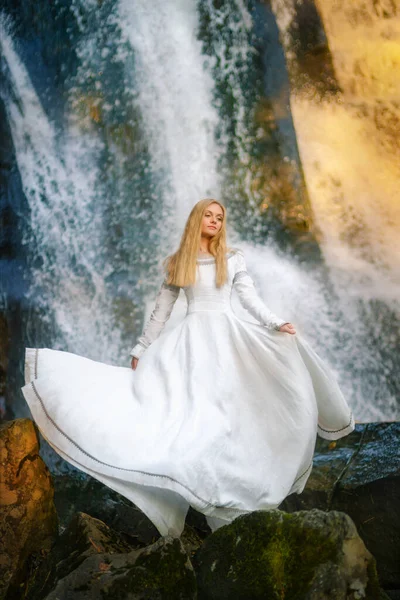 Красива молода жінка в білій сукні посеред лісу Стокове Фото