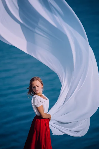 Bella ragazza con tessuto bianco su sfondo mare — Foto Stock