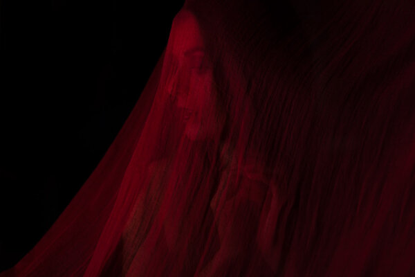 Девушка позирует с красной тканью
