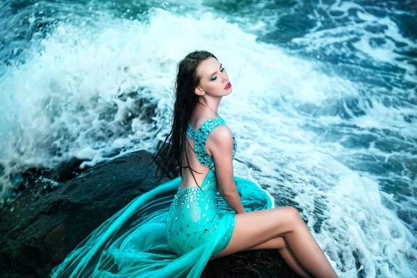 Frau posiert an einem Strand mit Felsen — Stockfoto