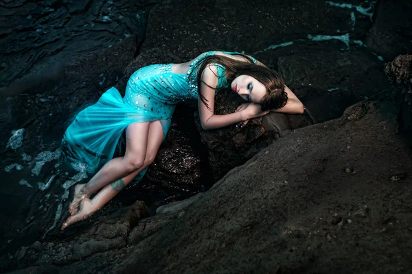 Mulher posando em uma praia com pedras — Fotografia de Stock