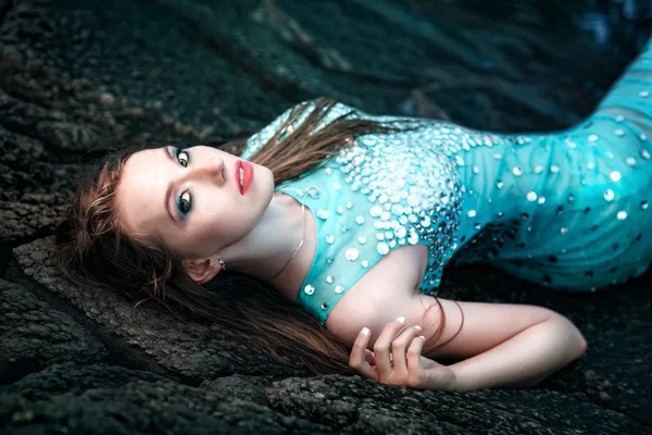 Vrouw die zich voordeed op een strand met rotsen — Stockfoto