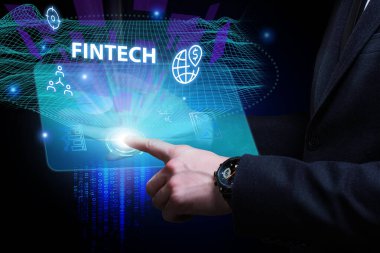 İş, Teknoloji, İnternet ve ağ konsepti. Genç işadamı geleceğin sanal ekranı üzerinde çalışıyor ve Fintech yazısını görüyor.