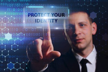 İş, Teknoloji, İnternet ve ağ konsepti. Genç işadamı geleceğin sanal ekranı üzerinde çalışıyor ve yazıyı görüyor: kimliğinizi koruyun.
