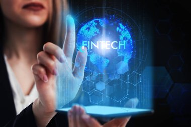 İş, Teknoloji, İnternet ve ağ konsepti. Genç işadamı geleceğin sanal ekranı üzerinde çalışıyor ve Fintech yazısını görüyor.