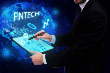 İş, Teknoloji, İnternet ve ağ konsepti. Genç işadamı geleceğin sanal ekranı üzerinde çalışıyor ve Fintech yazısını görüyor.