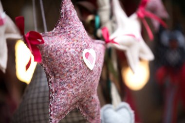 Kırmızı kumaş yıldızı yakın plan. Noel ve yeni yıl için el yapımı çelenkler. Xmas dekorasyonu için doğal malzemeler. Kartpostal resmi. Arka plan bulanık. Ev tasarımı için el sanatları.