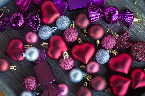 Noel süslemelerinin en üst görüntüsü. Noel ağacı için bir sürü küçük renkli kalp, top ve şeker. Tatil arkaplan kompozisyonu. Yeni yıl oyuncakları. Düz tabaka. Davetiye geçmişi. Şefkat ve sevgi