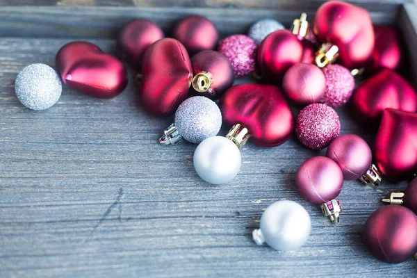 Tiny red and silver decorations for Christmas tree. New year toys, hearts and balls on wooden grey surface. Flat layer composition for winter holiday card. Invitation background. Tender and love — Stock Photo, Image