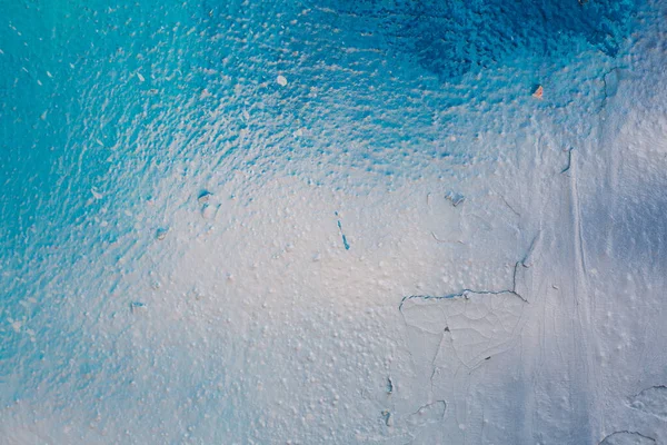 Çimento duvarında mavi ve beyaz alçı lekeleri var. Arka plan fotoğrafı. Duvar kağıdı desenli resim. Üst Manzara. Boyalar ve cilalar.