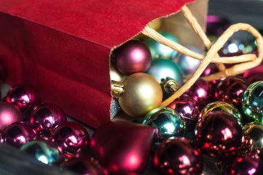 Renkli Noel toplarıyla birlikte küçük bir şarap rengi hediye paketi. Hediyeler hazırlanıyor. Küçük Xmas ağacı için çok renkli yeni yıl süslemeleri. Kartpostal resmi. Kutlama konsepti. Yeşil. Kırmızı ve Tiffany elementleri