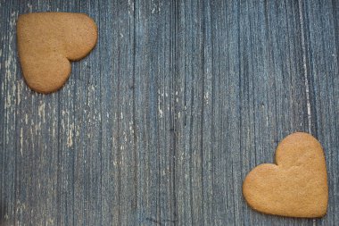 Gri ahşap arka plan ve iki köşede zencefilli bisküviler. Fotokopi alanı olan Aziz Sevgililer Günü çerçevesi. Aşk ve düğün davetiyesi duvar kağıdı. Sevimli kompozisyon. Sevgilim ol. 