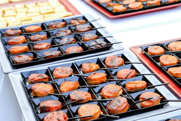 Yemek servisi için yakın plan. Kare siyah tabaklarda, küçük kaşıklarla küçük oryantal atıştırmalıklar. Gurme yemek degulasyonu. Menü konsepti resmi. Sağlıklı beslenme. kurumsal parti atıştırmalıkları