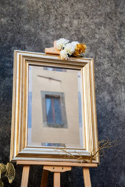 Çiçeklerle süslü sehpada zarif bir ayna, süslenmiş ayna ve şehir manzarası içeren zarif bir portre.