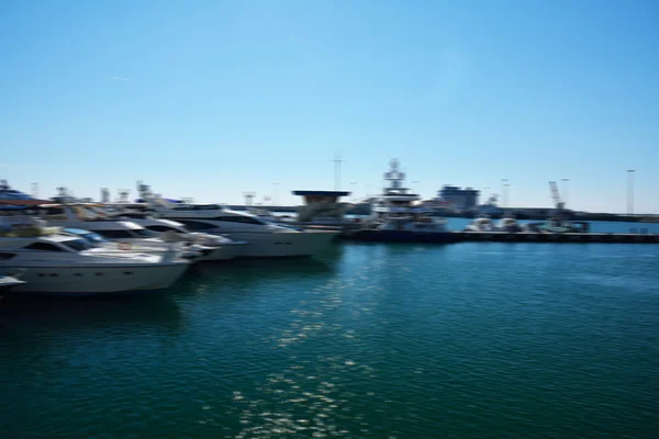 Lodě v přístavu za slunečného počasí, s mořem viděným — Stock fotografie
