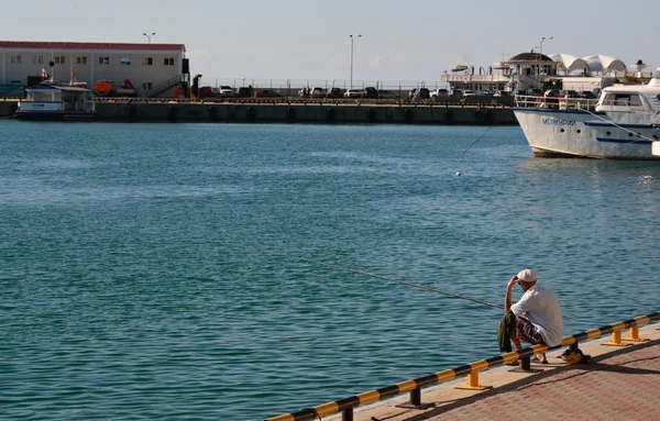 Vecchio pesca nel porto di mare — Foto Stock