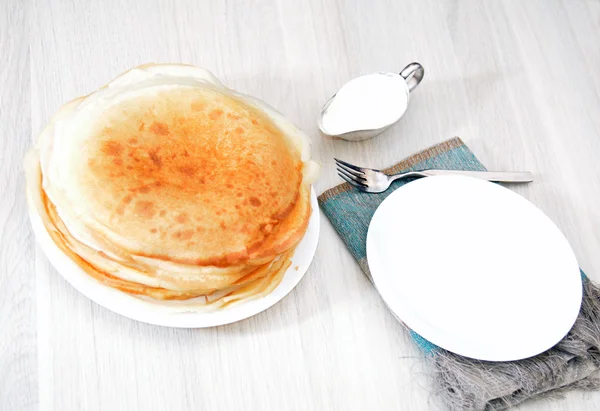 Pilha de panquecas na mesa com creme azedo — Fotografia de Stock