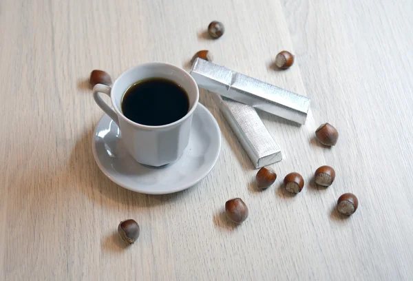 Cup of black coffee and two hazelnut chocolates with nuts — Stock Photo, Image