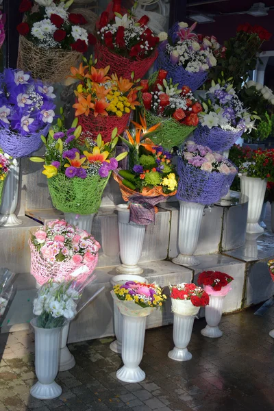 Bonitas flores frescas en floreros de plástico — Foto de Stock