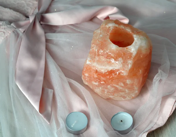 Orange salt lamp with candles on pink — Stock Photo, Image