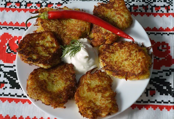 Dünne Kartoffelpfannkuchen - serviert mit saurer Sahne und scharfer Paprika lizenzfreie Stockbilder