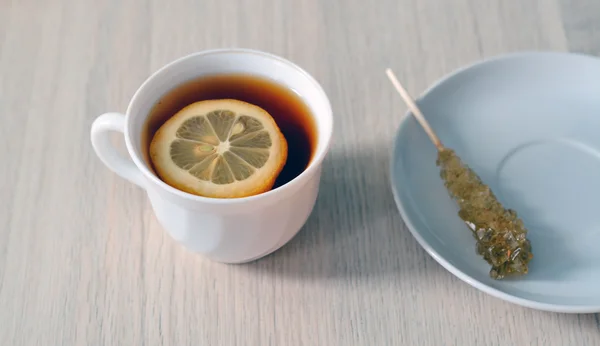 Tasse Tee mit Zitrone und Zuckerstange — Stockfoto
