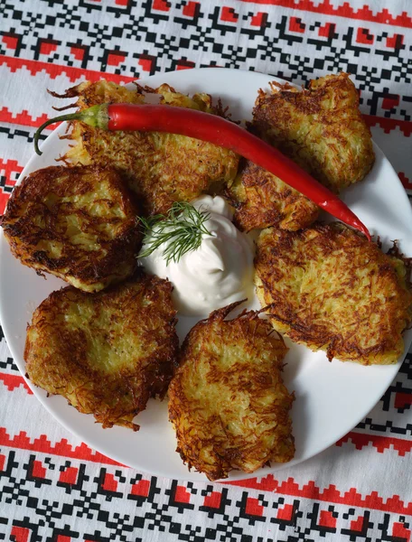 Deruni (potato pancakes) on a traditional ukrainian towel — Stock Photo, Image