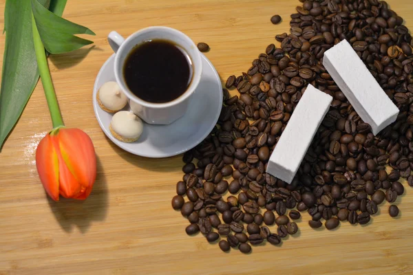 Cup of hot mocca coffee with vanilla pastille on coffee beans — Stock Photo, Image