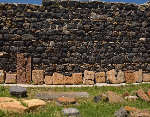 Row of broken khachkars next to the wall, Sevanavank — Stock Photo, Image