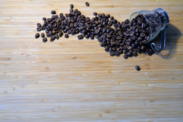 Coffee beans spilled out of a glass coffee cup — Stock Photo, Image