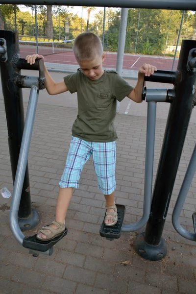 A boy doing exercises on the outdoor equipment — Stock Photo, Image