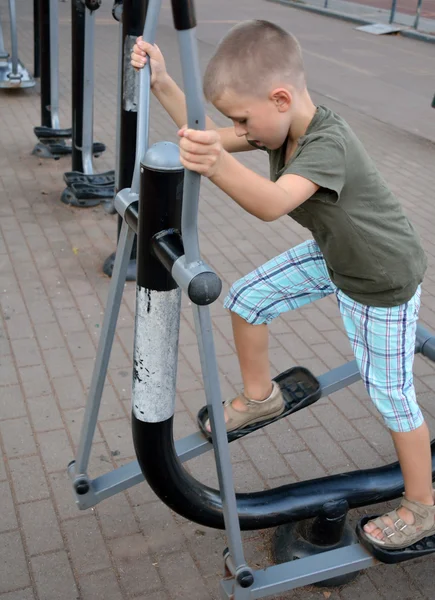 A boy starting to train on the fitness equipment — Stock Photo, Image