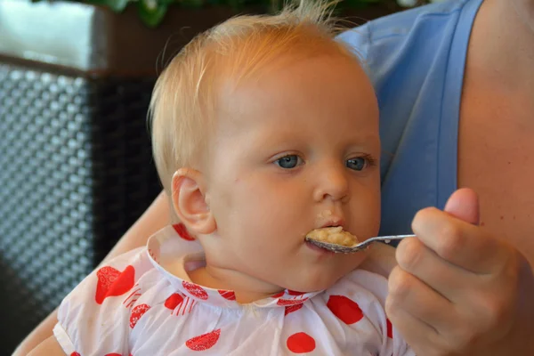 A baby girl eating gomogenised food from the spoon — Stock Photo, Image