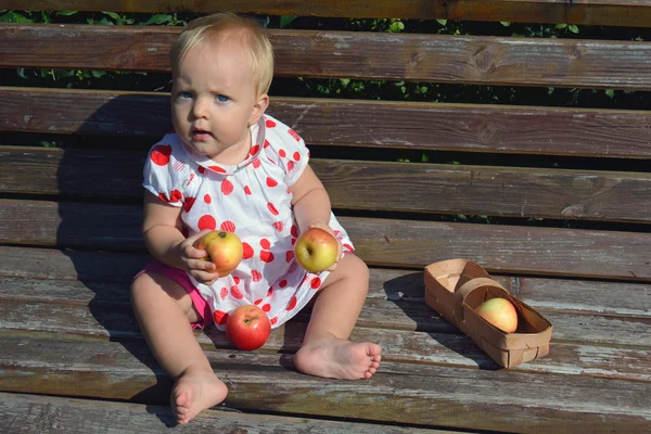 A baby girl holding an apple in her hands — Stock Photo, Image