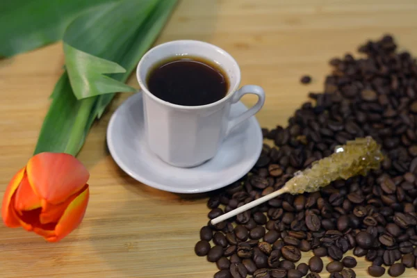 Bebida de café quente, flor, vara de açúcar e grãos de café — Fotografia de Stock