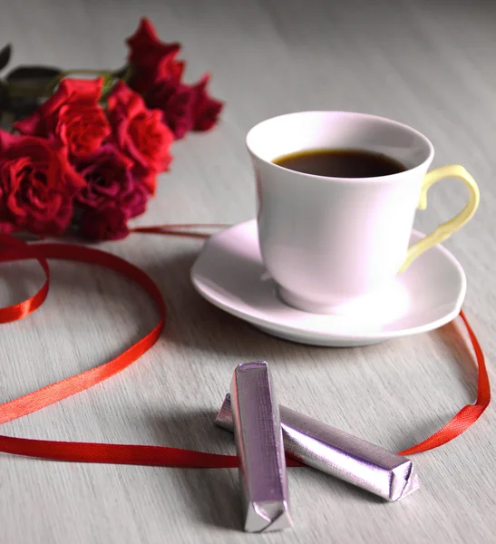 Taza de café con rosas rojas y cinta — Foto de Stock