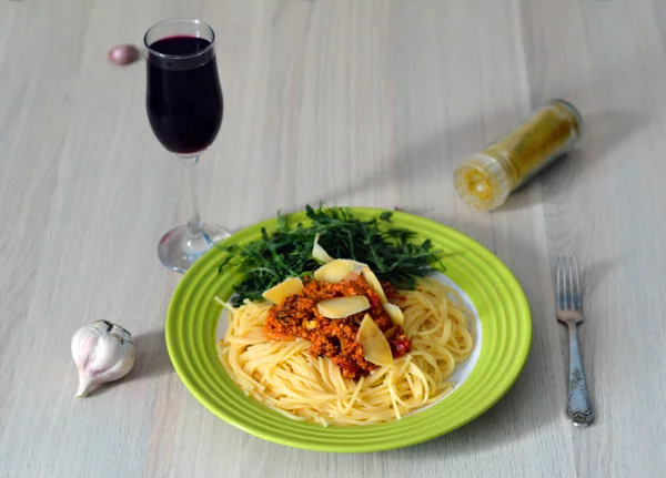 Espaguetis boloñeses con trozos de queso, ruccola y vino tinto — Foto de Stock