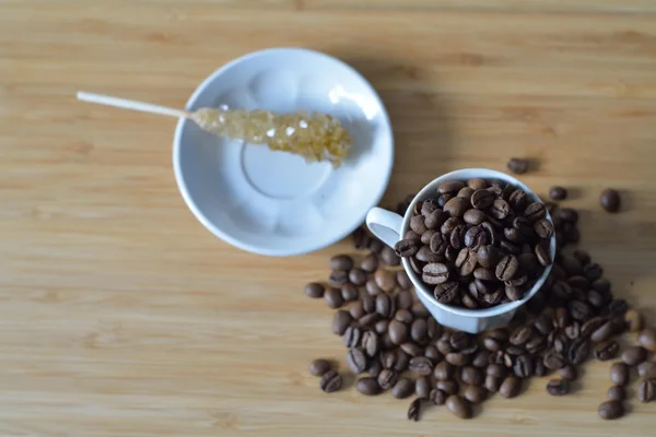 Coffee beans in a cup, candy stick — Stock Photo, Image