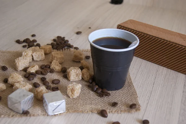 Cup of fresh coffee with chocolates and sugar — Stock Photo, Image