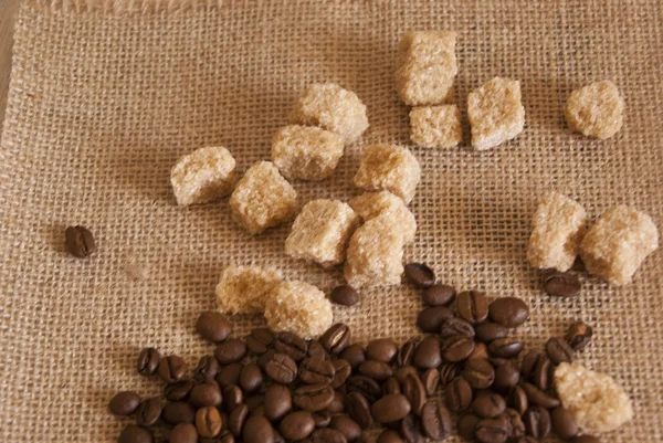 Stapel van koffiebonen en stukken van suiker — Stockfoto