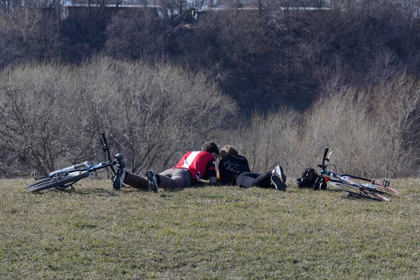 Pareja descansando en el parque con bicicletas tumbadas — Foto de Stock