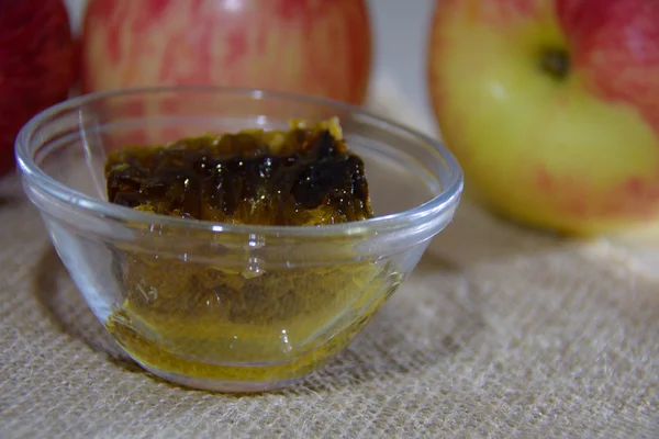 Closeup of honey in a bowl, with apples — Stock Photo, Image