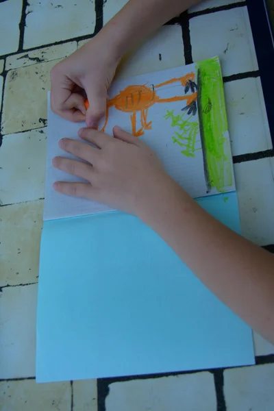 Mains d'enfant dessinant un dinosaure — Photo